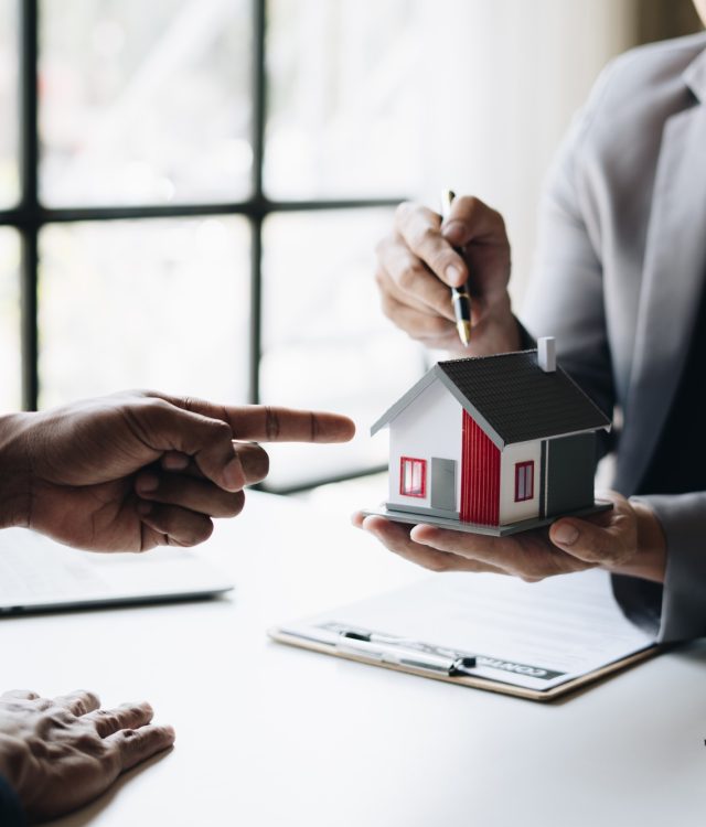 Real estate agent holding house key to his client after signing contract,concept for real estate.